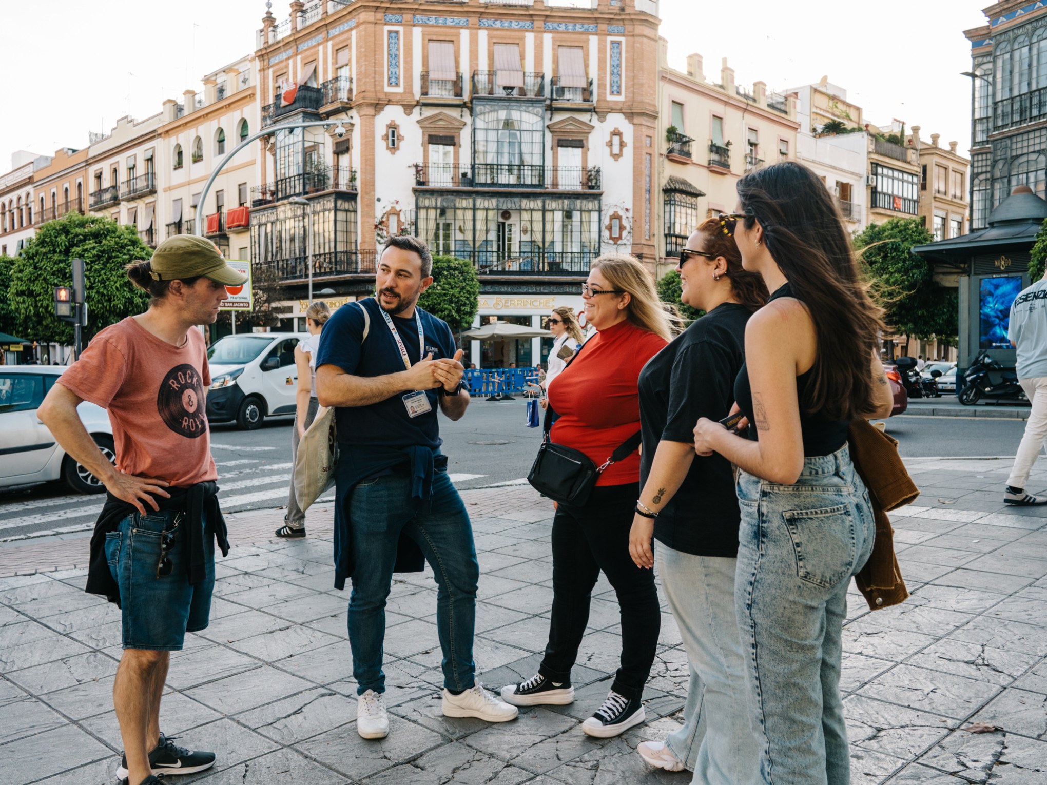 Group of five people chatting on a city street, surrounded by historic buildings.