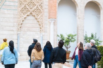 Group of people looking at ornate building façade.
