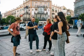 A group of people talking on a city street corner with historic buildings.