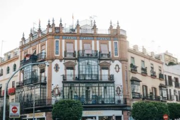 Ornate building with balconies and large windows on a sunny day.